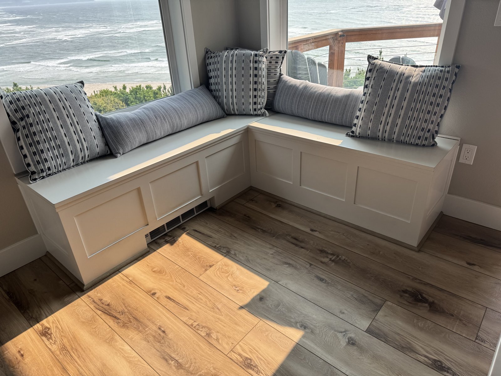 L-shaped storage bench corner detail with raised panel and pillows