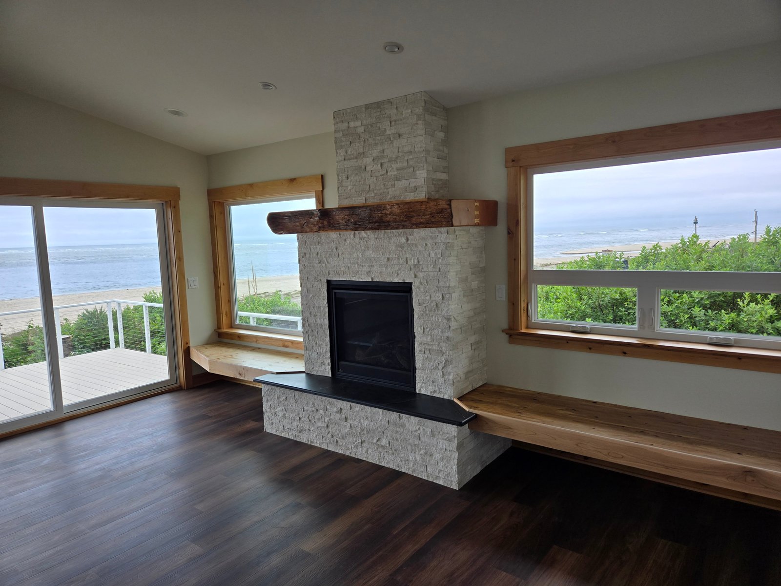 Fireplace with mantle and ocean view through sliding doors