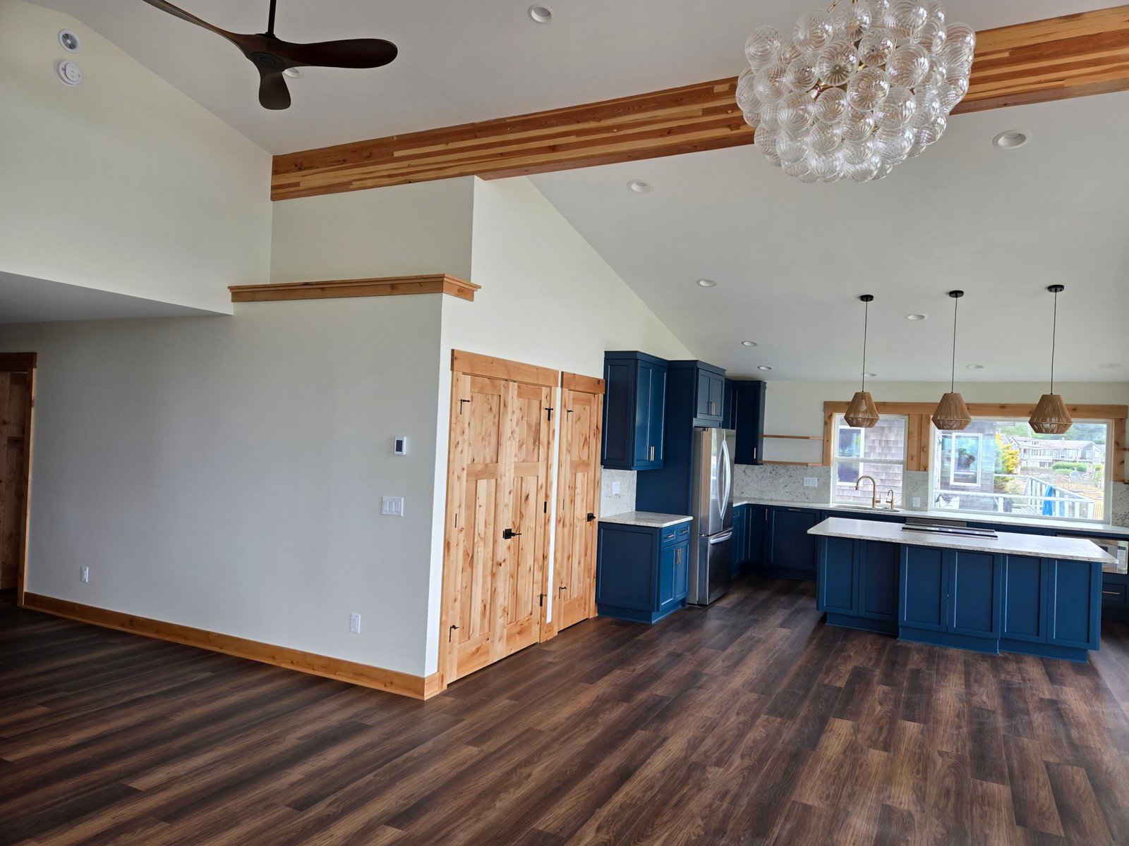 Finished blue kitchen wide shot with alder doors and pendant lights