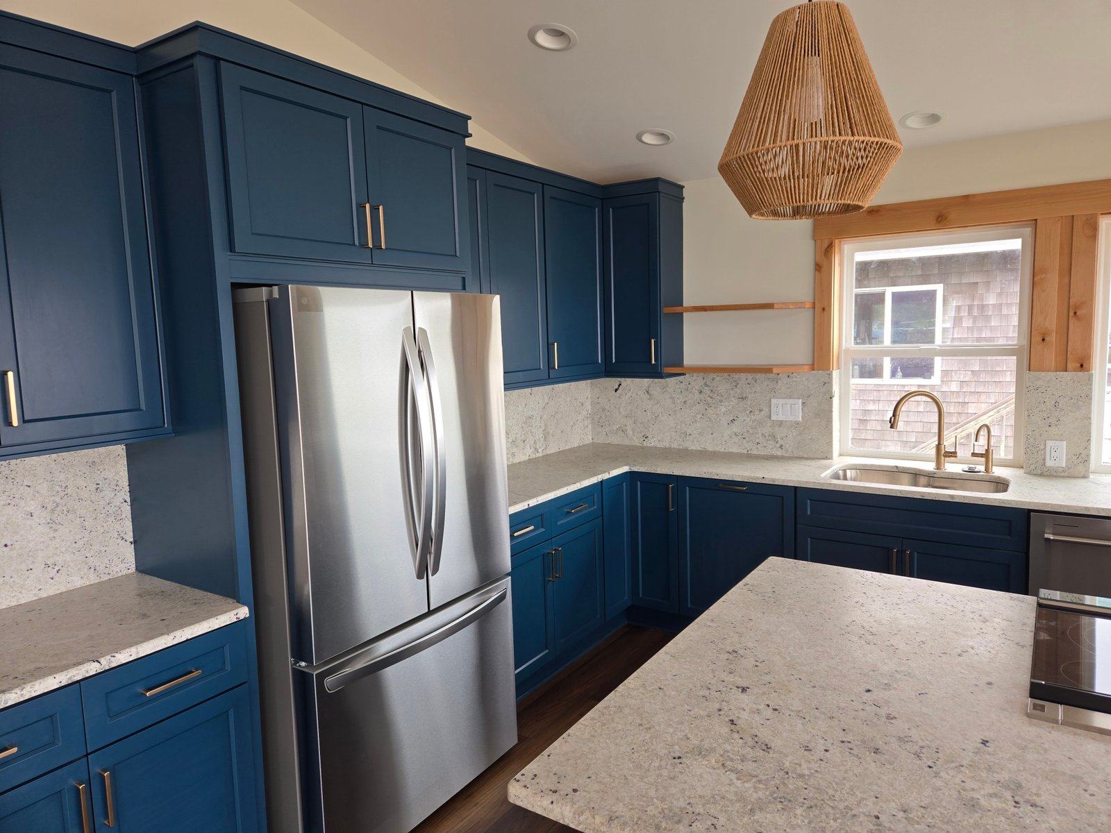 Blue kitchen close-up with gold hardware and granite countertops