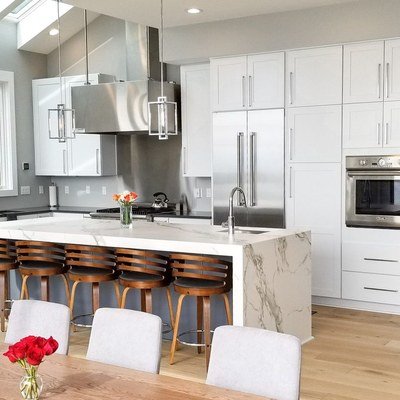 Casey Jay Winters Construction white shaker cabinet installation in modern kitchen with marble island, Tillamook Oregon